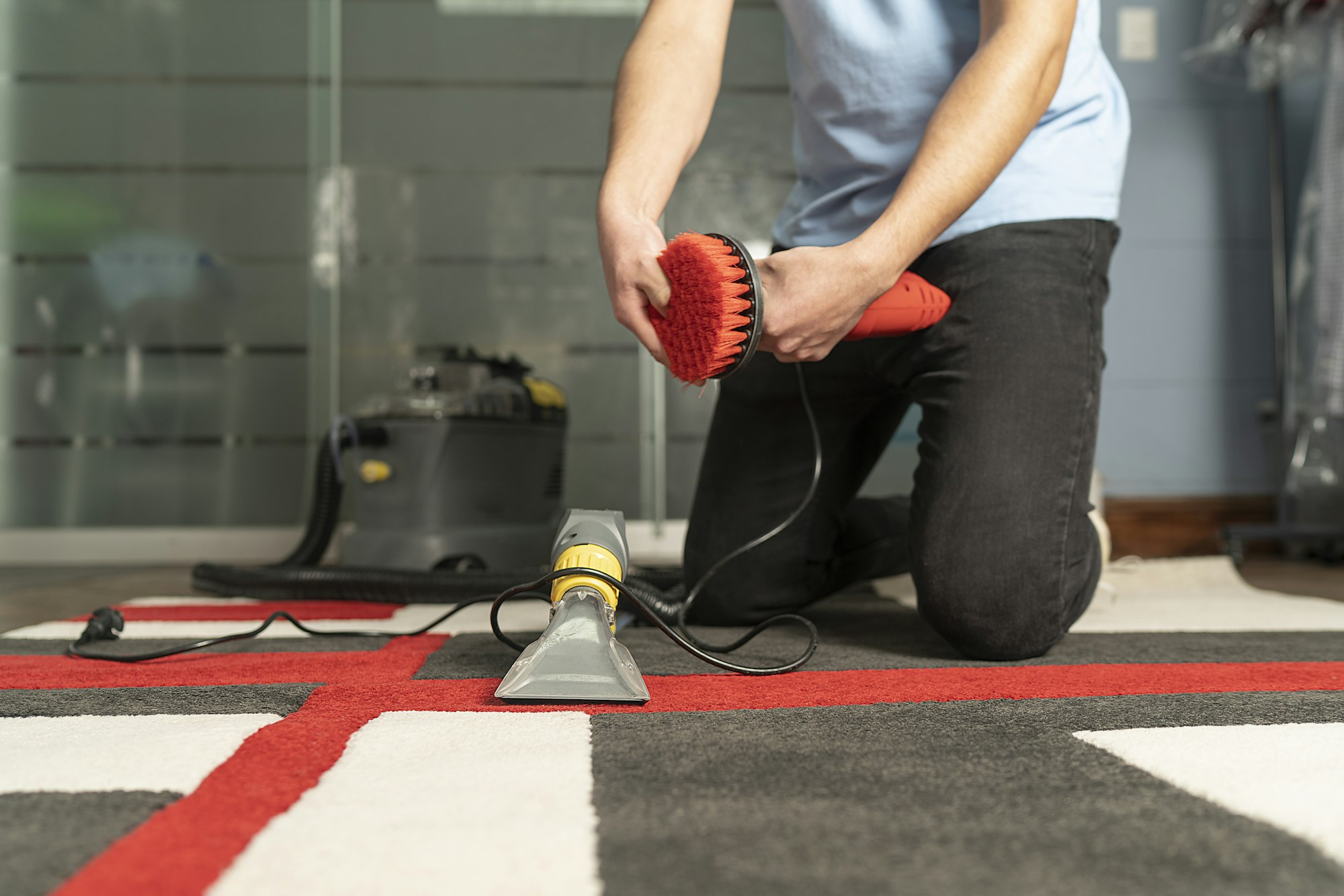 Unrecognizable laundry personnel cleaning carpet with special equipment